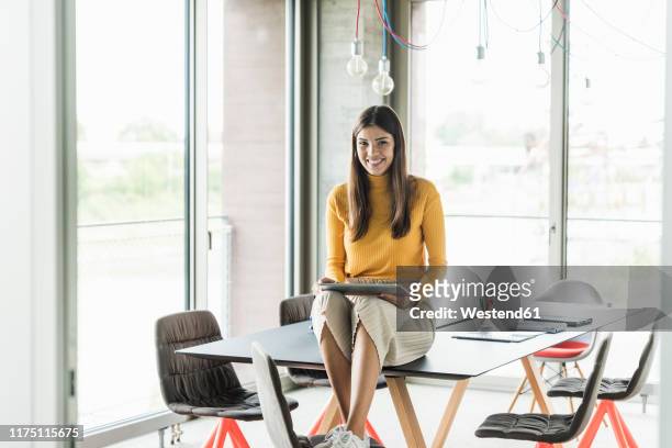 portrait of smiling young businesswoman with tablet in office - draft portraits stock-fotos und bilder
