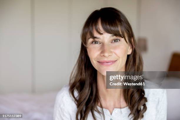 portrait of smiling woman at home - older woman with brown hair foto e immagini stock
