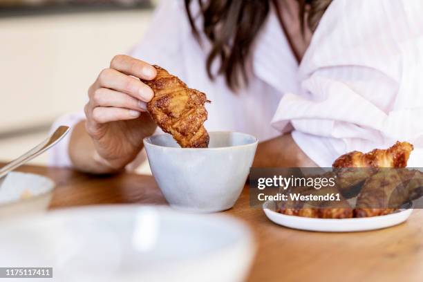 close-up of woman dipping a croissant into coffee cup - hand pastry stock pictures, royalty-free photos & images