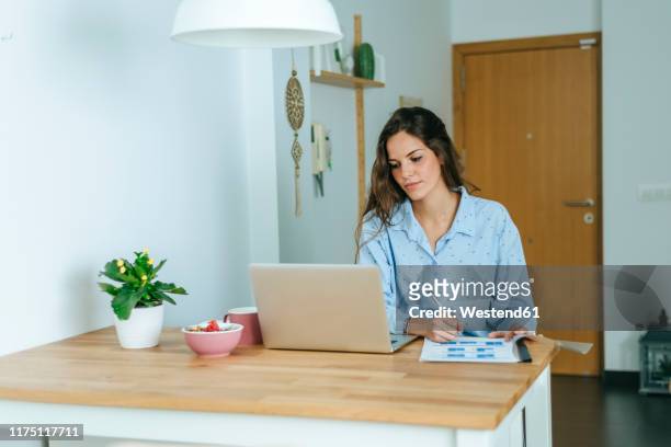 young woman using laptop during breakfast at home - pyjamas stock pictures, royalty-free photos & images