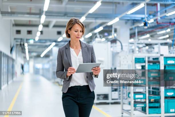 businesswoman with tablet in a modern factory - digitization stockfoto's en -beelden