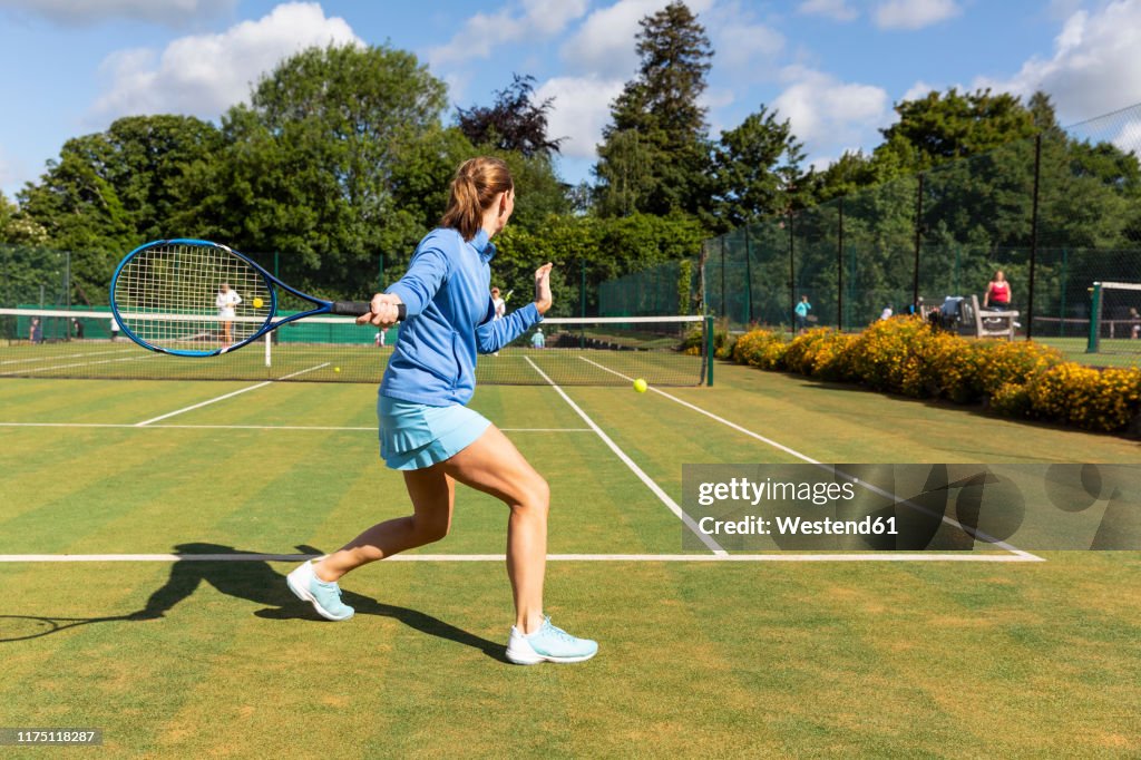 Mature woman during a tennis match on grass court