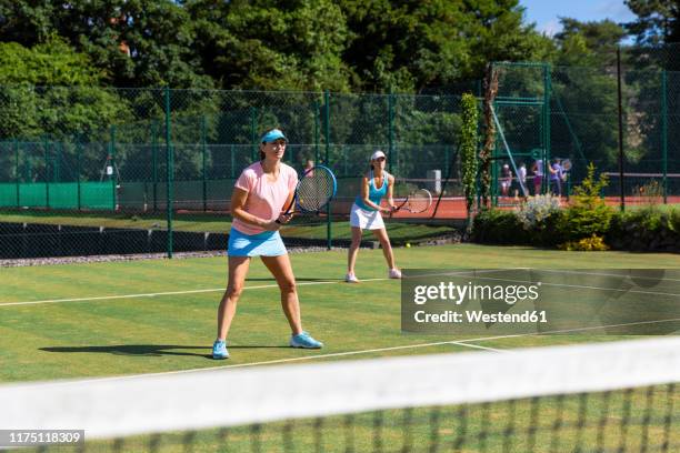 mature women during a tennis match on grass court - doubles stock pictures, royalty-free photos & images