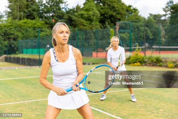 mature women during a tennis match on grass court - テニス 女性 ストックフォトと画像