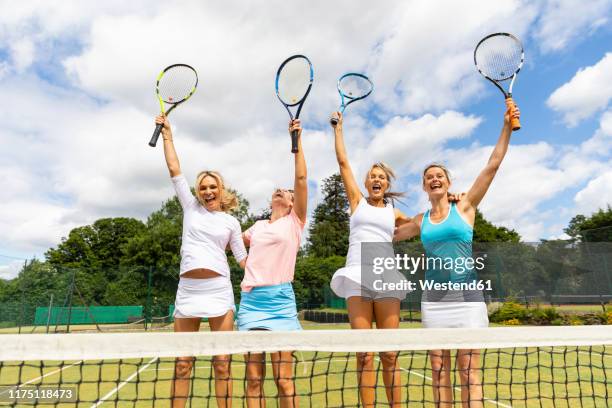 happy female tennis players celebrating the victory on grass court - racquet sport stock pictures, royalty-free photos & images