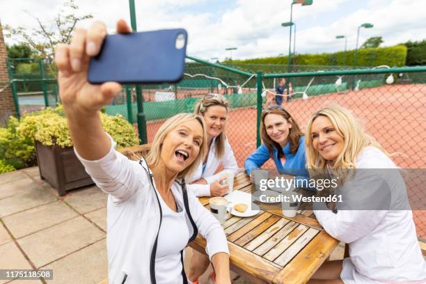 group of women taking a selfie at tennis club after a match - women's table tennis stock-fotos und bilder