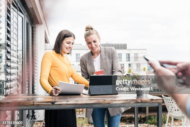 two casual businesswomen meeting on roof terrace - man talking at the phone outdoor stock-fotos und bilder