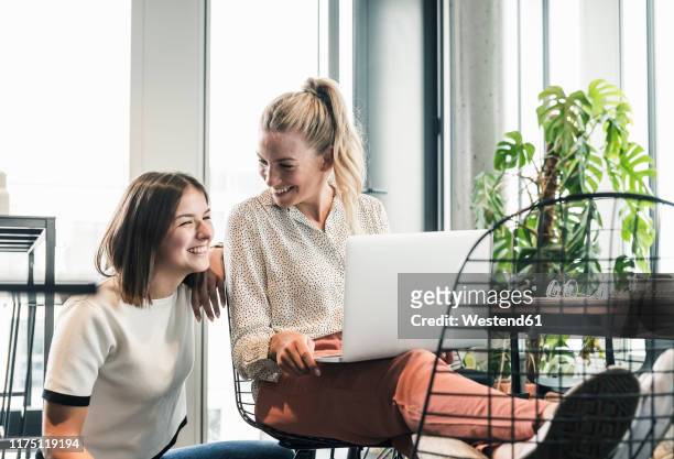 two happy casual businesswomen with laptop meeting in office - coworkers having fun stock pictures, royalty-free photos & images