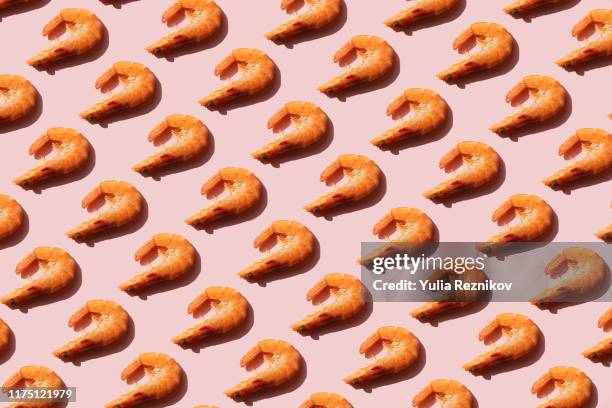 repeated shrimps on the pink background - garnaal vis en zeevruchten stockfoto's en -beelden