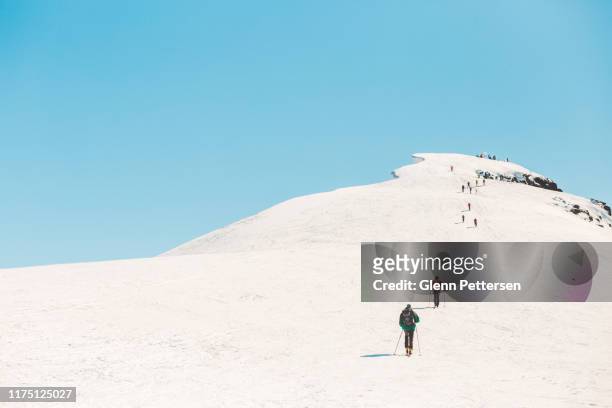 uitzicht op skiërs op besneeuwde berg in sunnmore, noorwegen. - telemark skiing stockfoto's en -beelden