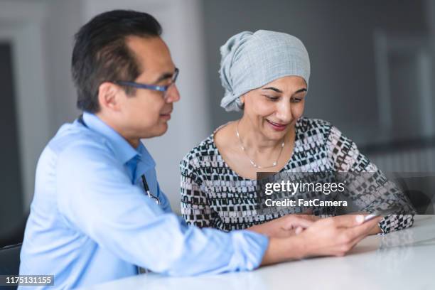 woman with cancer reviews test results with male doctor - chemotherapy man stock pictures, royalty-free photos & images