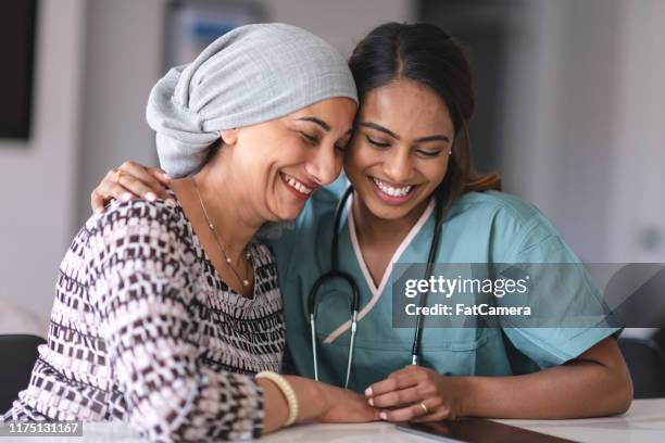 portret van een indiase vrouw met kanker en haar arts - kankercel stockfoto's en -beelden