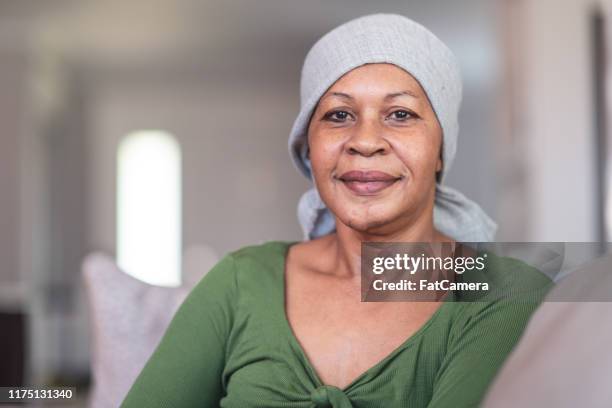 portret van een contemplatieve vrouw met kanker - headscarf home stockfoto's en -beelden