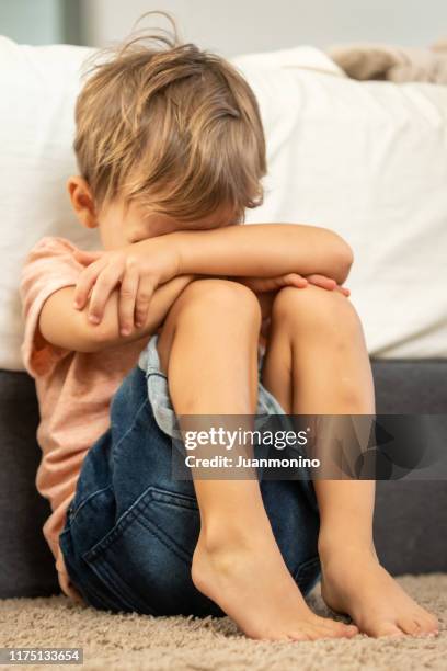 crying child boy sitting on the floor covering his face - mental illness child stock pictures, royalty-free photos & images