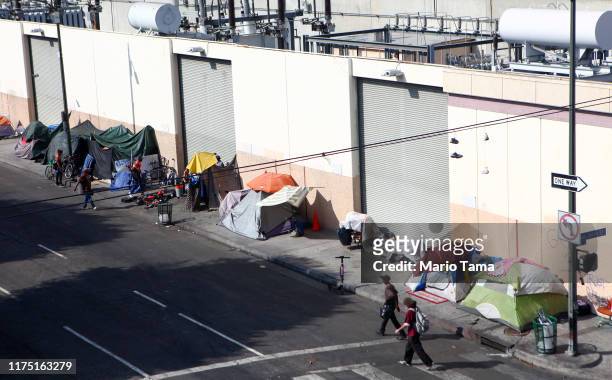 People walk past a homeless tent encampment in Skid Row on September 16, 2019 in Los Angeles, California. Skid Row is home to thousands who either...
