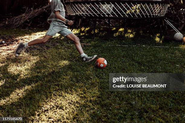mid kick action shot! - football australien stock pictures, royalty-free photos & images
