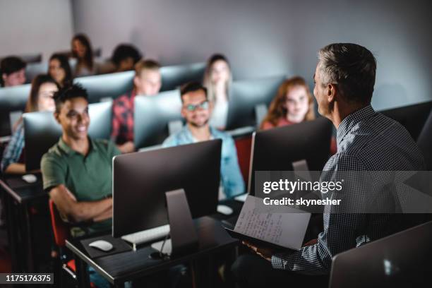 profesor varón de adulto medio enseñando la clase en el laboratorio de computación. - male professor with students fotografías e imágenes de stock