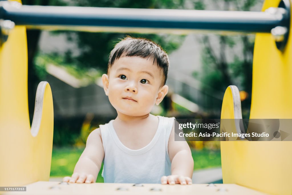 Asian baby is playing outside.