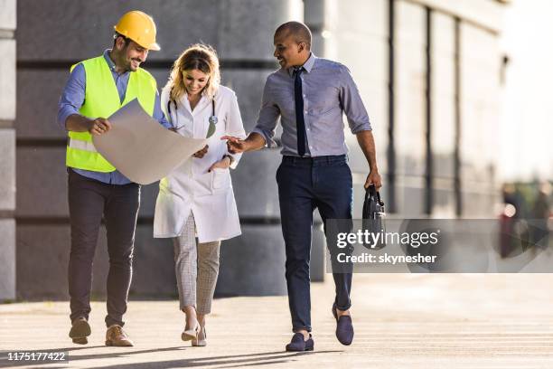 examining blueprints on the move! - doctor and engineer stock pictures, royalty-free photos & images