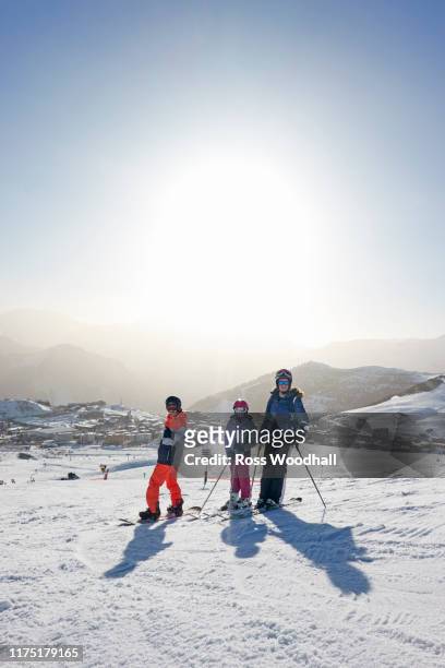 skiers, mother with daughter and teenage son on snow covered mountain top, portrait,  alpe-d'huez, rhone-alpes, france - アルプデュエーズ ストックフォトと画像