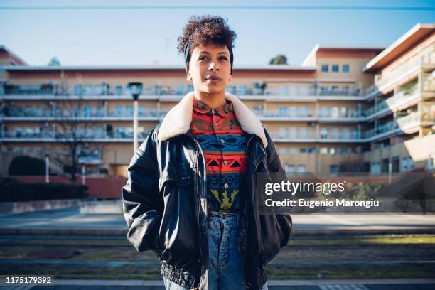 cool young woman on urban sidewalk looking up, portrait - junge frau allein stock-fotos und bilder