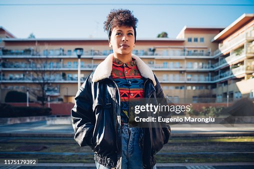 Cool young woman on urban sidewalk looking up, portrait Cool young woman on urban sidewalk looking up, portrait