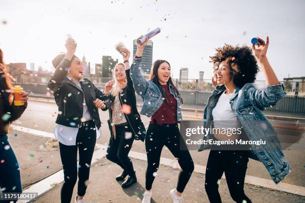 friends celebrating with confetti and soap bubbles in street, milan, italy - menschengruppe begeisterung stock-fotos und bilder