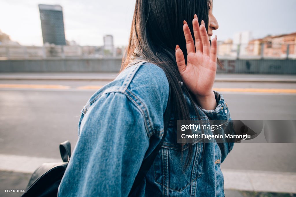 Woman shying away from being photograph, Milan, Italy