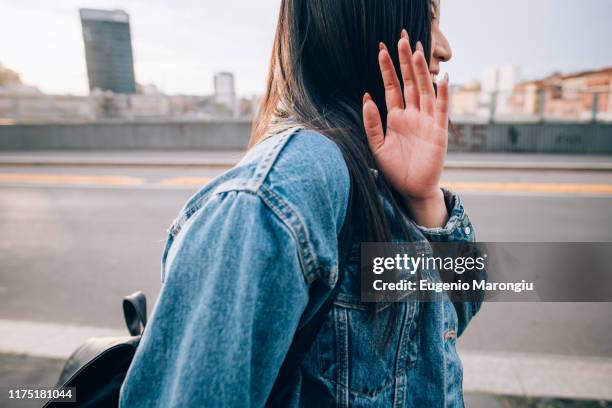 woman shying away from being photograph, milan, italy - tímido imagens e fotografias de stock