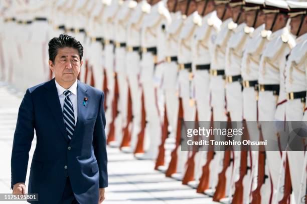 Japan's Prime Minister Shinzo Abe inspects an honor guard ahead of a Self Defense Forces senior officers' meeting at the Ministry of Defense on...