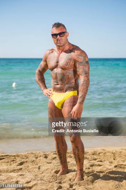 bodybuilder with tattoo wearing speedo - bodybuilder posing stock pictures, royalty-free photos & images