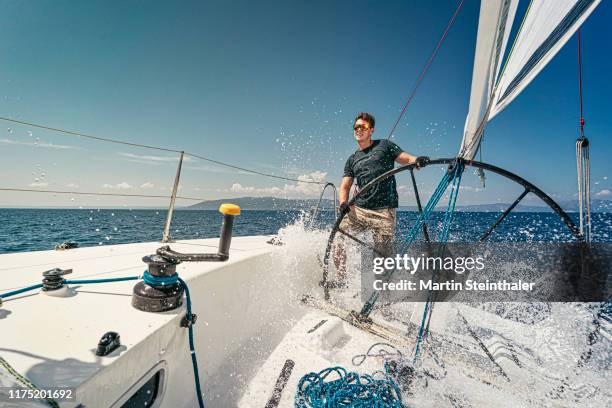 segelboot mit segler am offenen meer - welle bricht wasser spritzt - vela foto e immagini stock