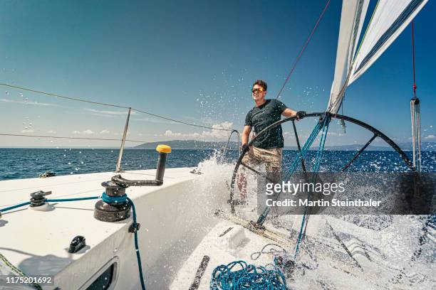 segelboot mit segler am offenen meer - welle bricht wasser spritzt - sail boat stock pictures, royalty-free photos & images