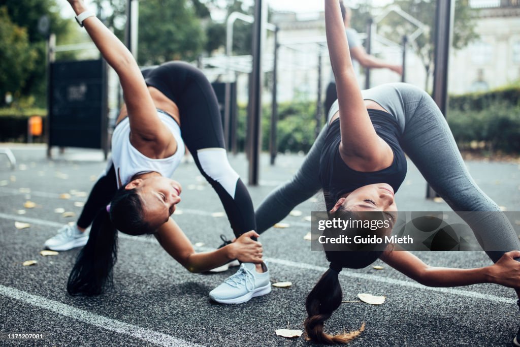 Girlfriends doing stretching before fitness training.
