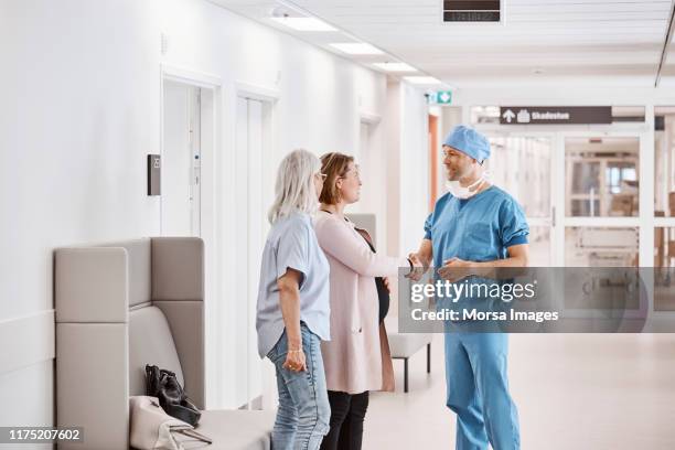 zwangere patiënt schudden handen met mannelijke arts - pregnant women greeting stockfoto's en -beelden