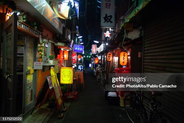 illuminated signs of shops and bar at night - tokyo japan night alley stock pictures, royalty-free photos & images