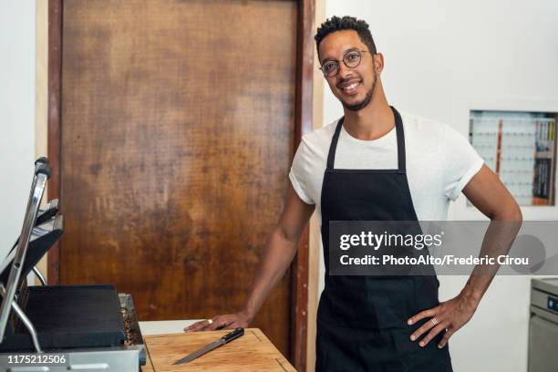 portrait of man standing in commercial kitchen - grembiule foto e immagini stock