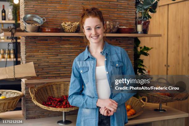 young woman standing in shop - corpetto foto e immagini stock