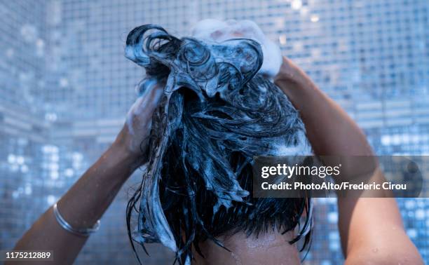 woman washing her hair - shampoo photos et images de collection