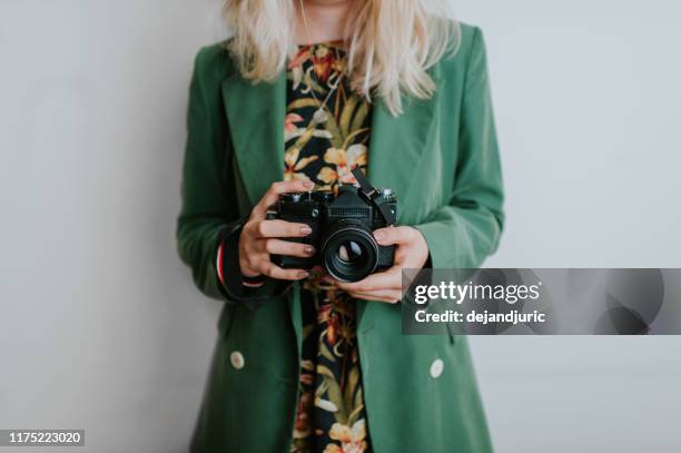 woman holding a camera - digitale spiegelreflexkamera stock-fotos und bilder