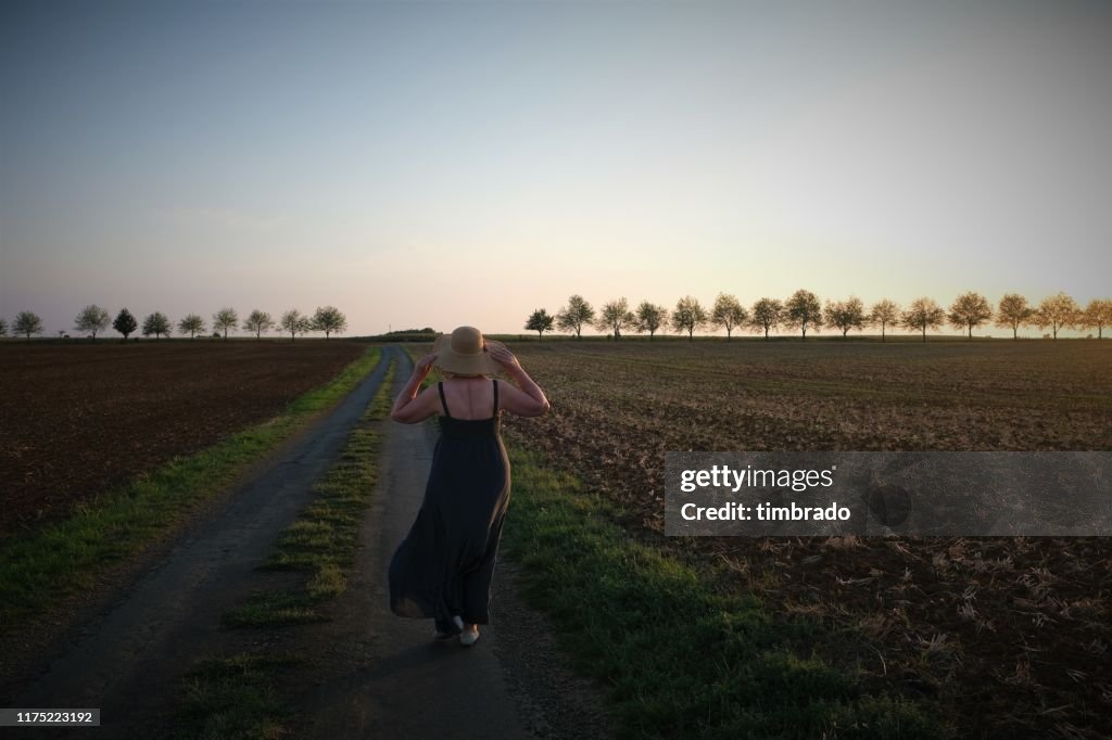 Woman walking along a rural road, Deux-Sevres, Nouvelle Aquitaine, France