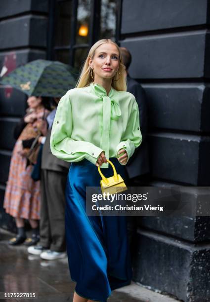 Leonie Hanne is seen wearing navy silk skirt, green blouse with tie, yellwo mini bag Jacquemus outside Christopher Kane during London Fashion Week...