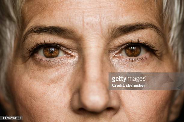 brown-eyed senior woman. - close up stock pictures, royalty-free photos & images