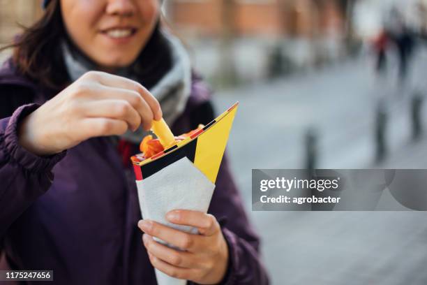 femme mangeant la pomme de terre de frites français avec le ketchup à bruxelles - culture belge photos et images de collection