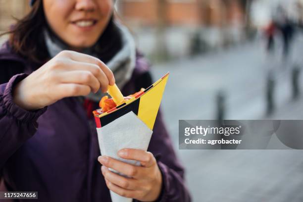 woman eating french fries potato with ketchup in brussels - cone shape stock pictures, royalty-free photos & images