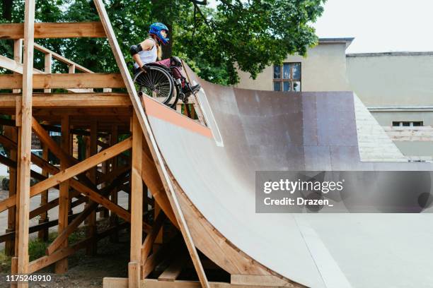 Behinderte Frau im Rollstuhl bei Stunts im Skatepark