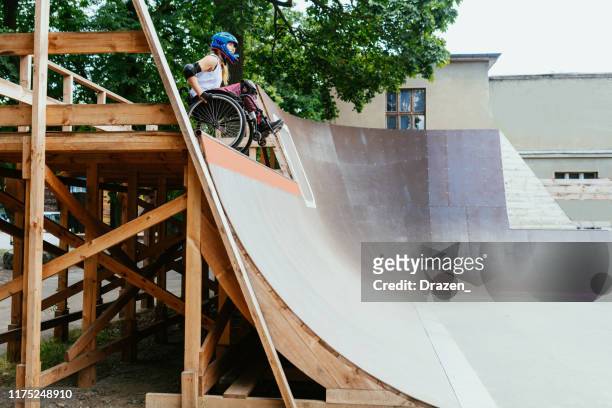 Disabled woman in wheelchair doing stunts in skate park