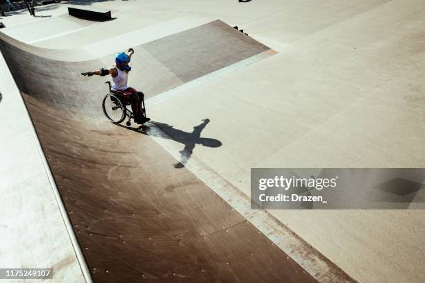 disabled woman in wheelchair doing stunts in skate park - disabled extreme sports stock pictures, royalty-free photos & images