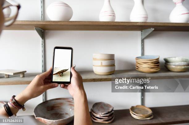 woman photographing her products for sale - photography themes stock pictures, royalty-free photos & images