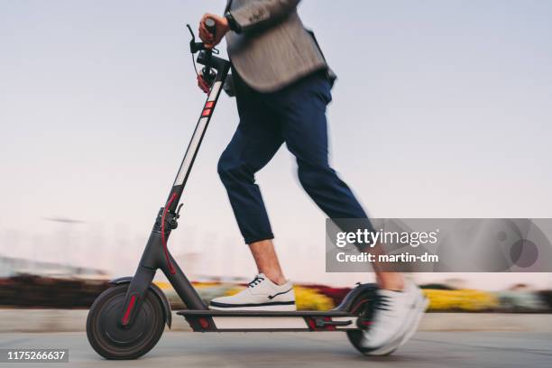 businessman riding a motor scooter in sofia - scooter stock pictures, royalty-free photos & images
